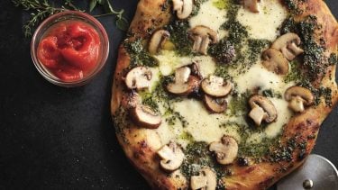 Homemade pizza dough, cooked into mushroom surpreme with fresh pesto, mozzarella and brown mushrooms