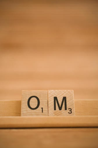 OM, two Scrabble pieces show a mantra
