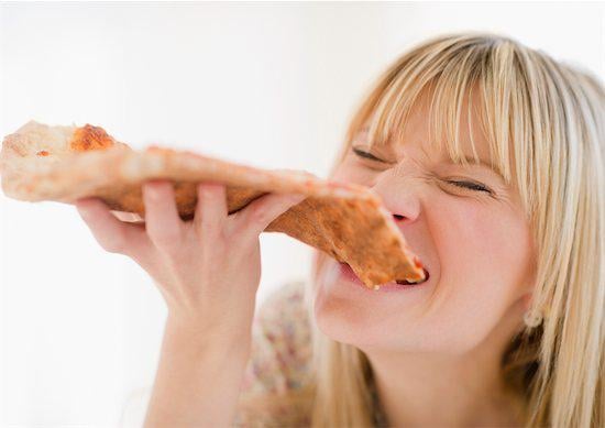 Woman eating a slice of pizza