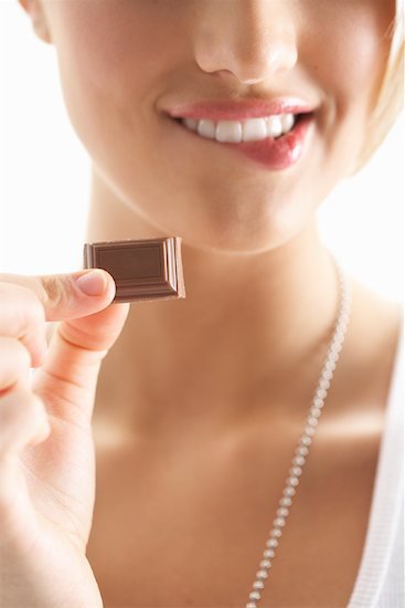 woman holding a piece of chocolate