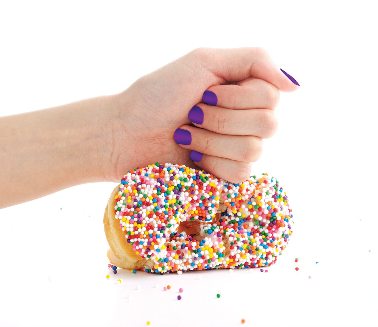 Fist squashing a donut with sprinkles
