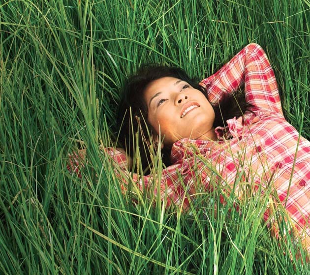 Woman in Checked Shirt Lying in Grass