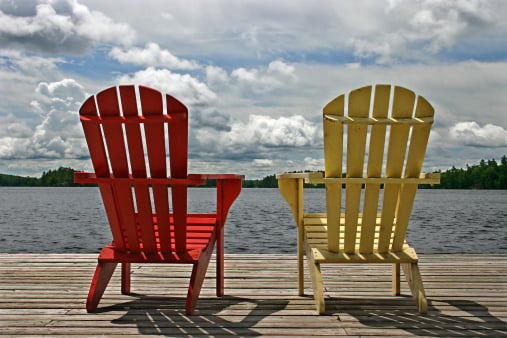 muskoka chairs on dock by lake