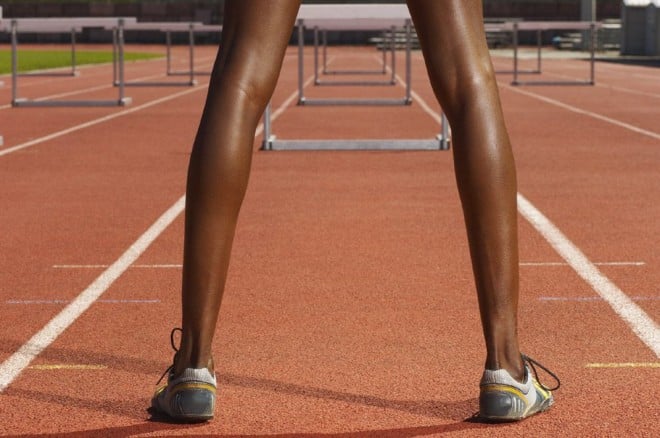 Woman standing on a track before hurdles