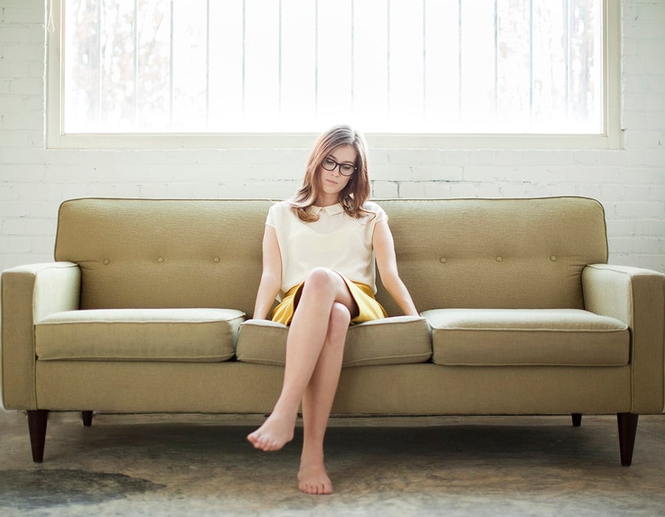 Woman sitting with crossed legs and glasses