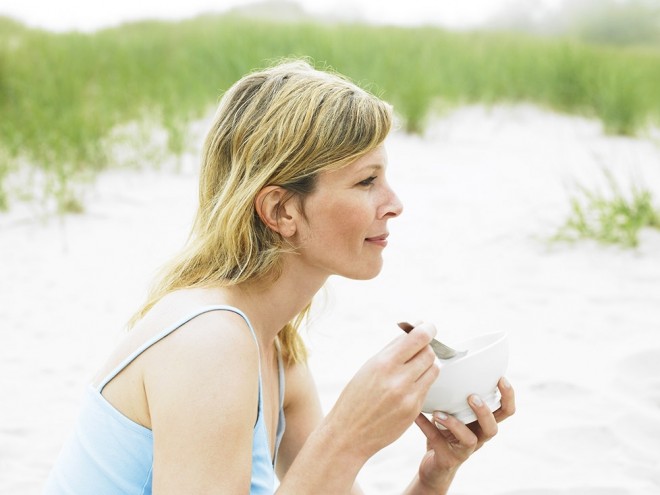 Woman eating healthy on the beach
