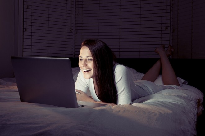 Girl on computer at night in bed