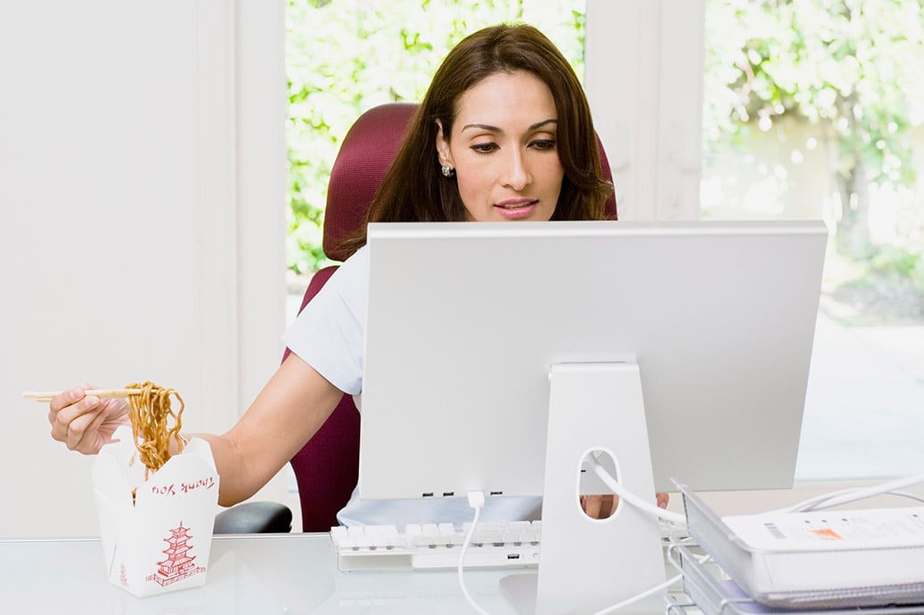 Woman eating lunch at her desk, chinese food