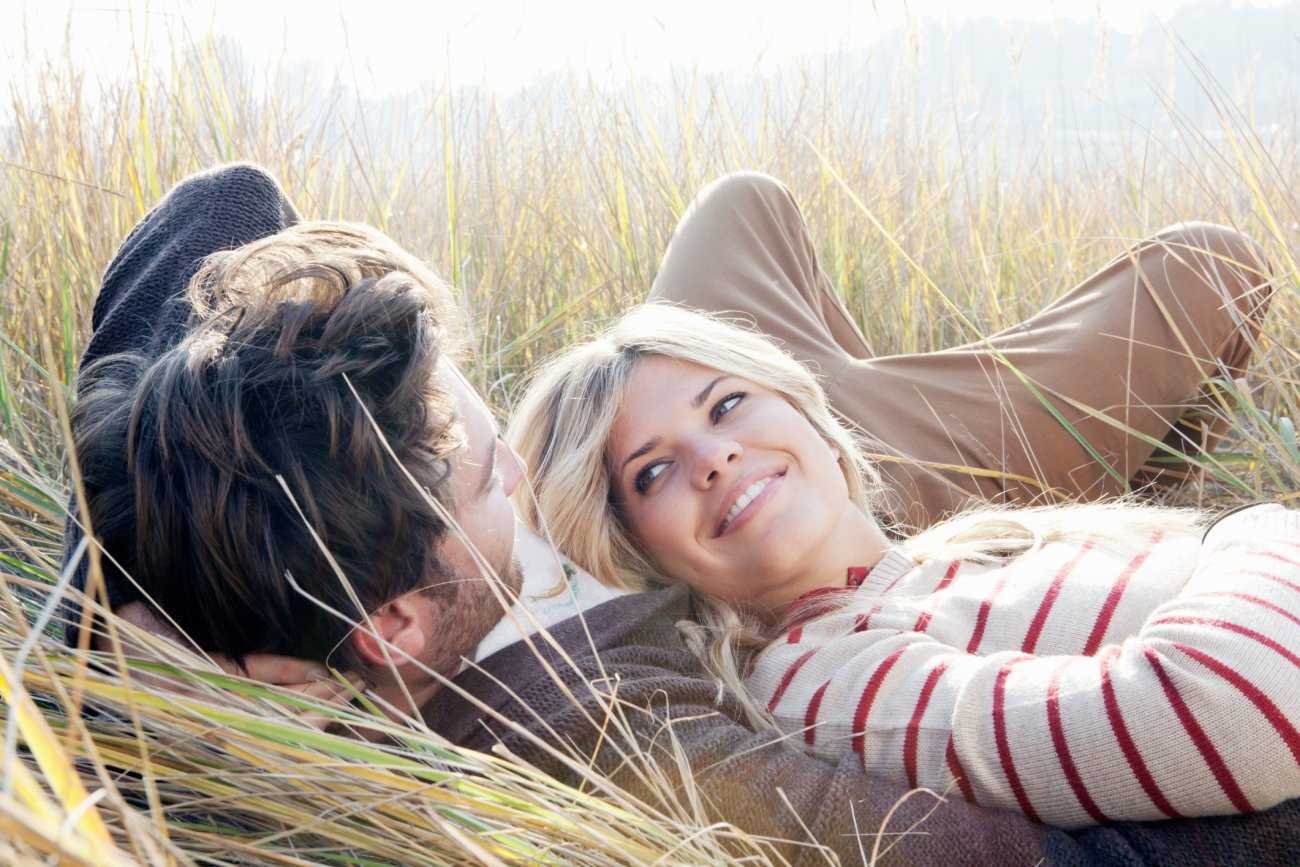 Young happy couple laying in the grass