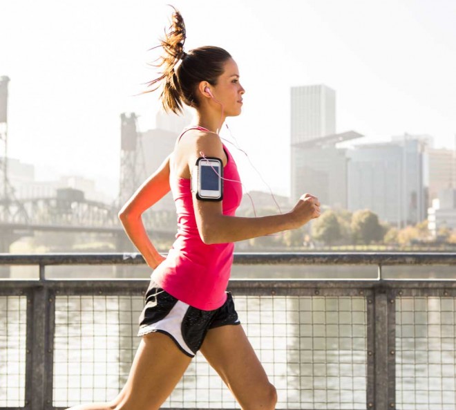 A female listening to music and jogging across a bridge in Portland, Oregon.