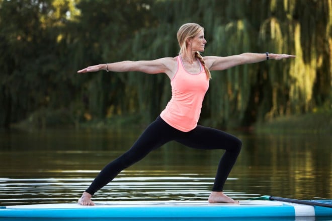 Woman practicing yoga on a paddle board.