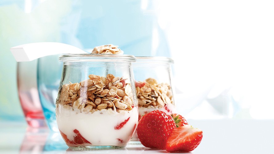 A jar of yogurt with granola and strawberries