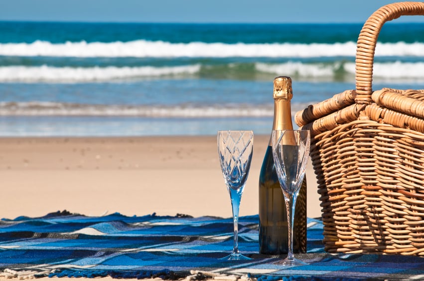 Picnic blanket,champagne,picnic basket and a beautiful tropical beach.