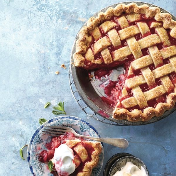 Rhubarb pie recipe: Blue background with rhubarb pie with one slice cut out, and a served slice on a side plate with vanilla ice cream