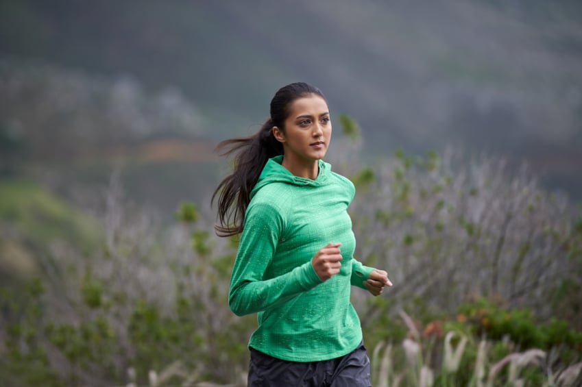 Shot of a woman sprinting along a mountain road on a crisp morning