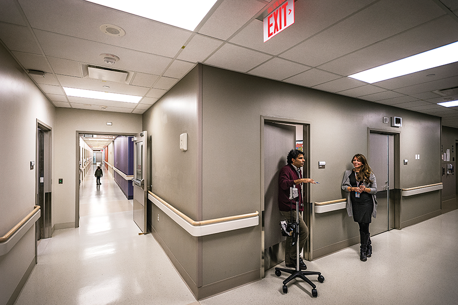 Dr. Meb Rashid speaks with nurse practitioner Vanessa Wright in the hallway of the Crossroads Clinic at Toronto’s Women’s College Hospital. 