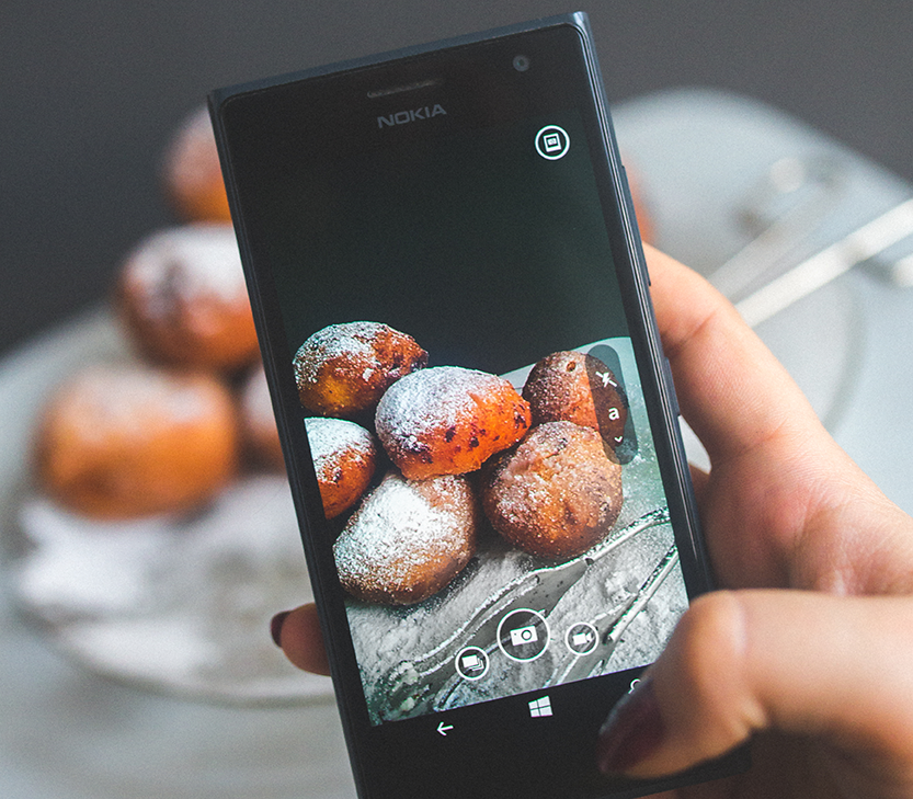 Woman taking picture of donuts with phone