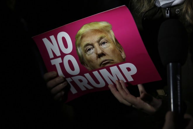 A woman holds a placard as she gives a television interview during an anti-racism protest against President-elect Donald Trump winning the American election, outside the U.S. embassy in London, Wednesday, Nov. 9, 2016. Democratic presidential candidate Hillary Clinton conceded her defeat to Republican Donald Trump after the hard-fought presidential election. (AP Photo/Matt Dunham)