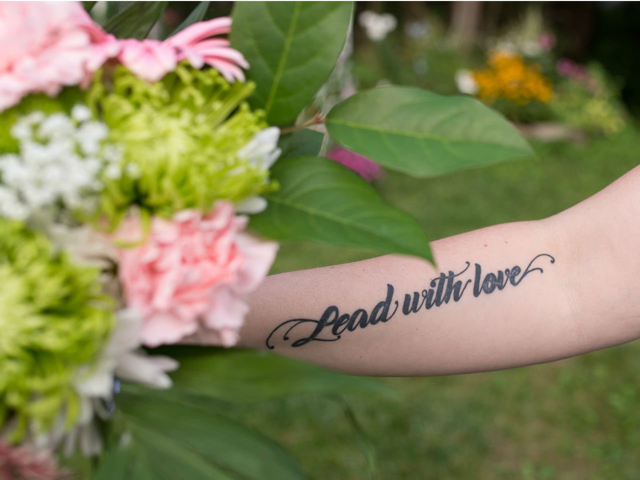 trans daughter-Forearm tattoo sating "Lead with Love."