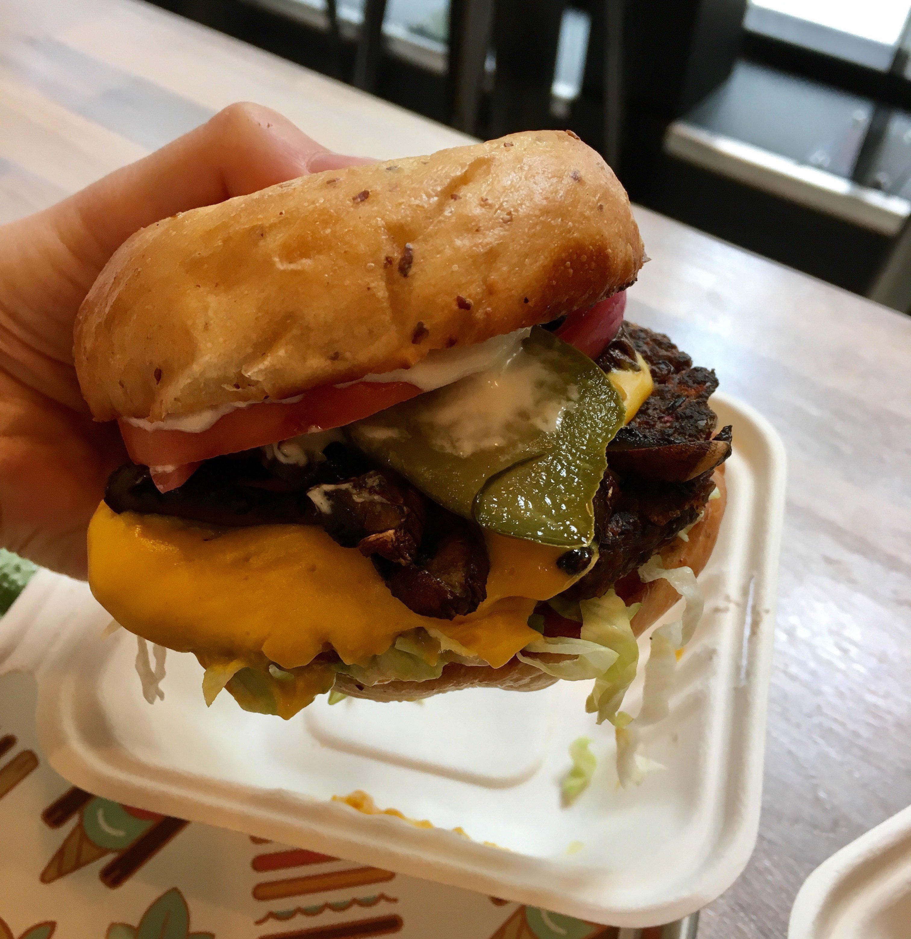 Plant-based Burger. Vegan cheeseburger with a pickle.