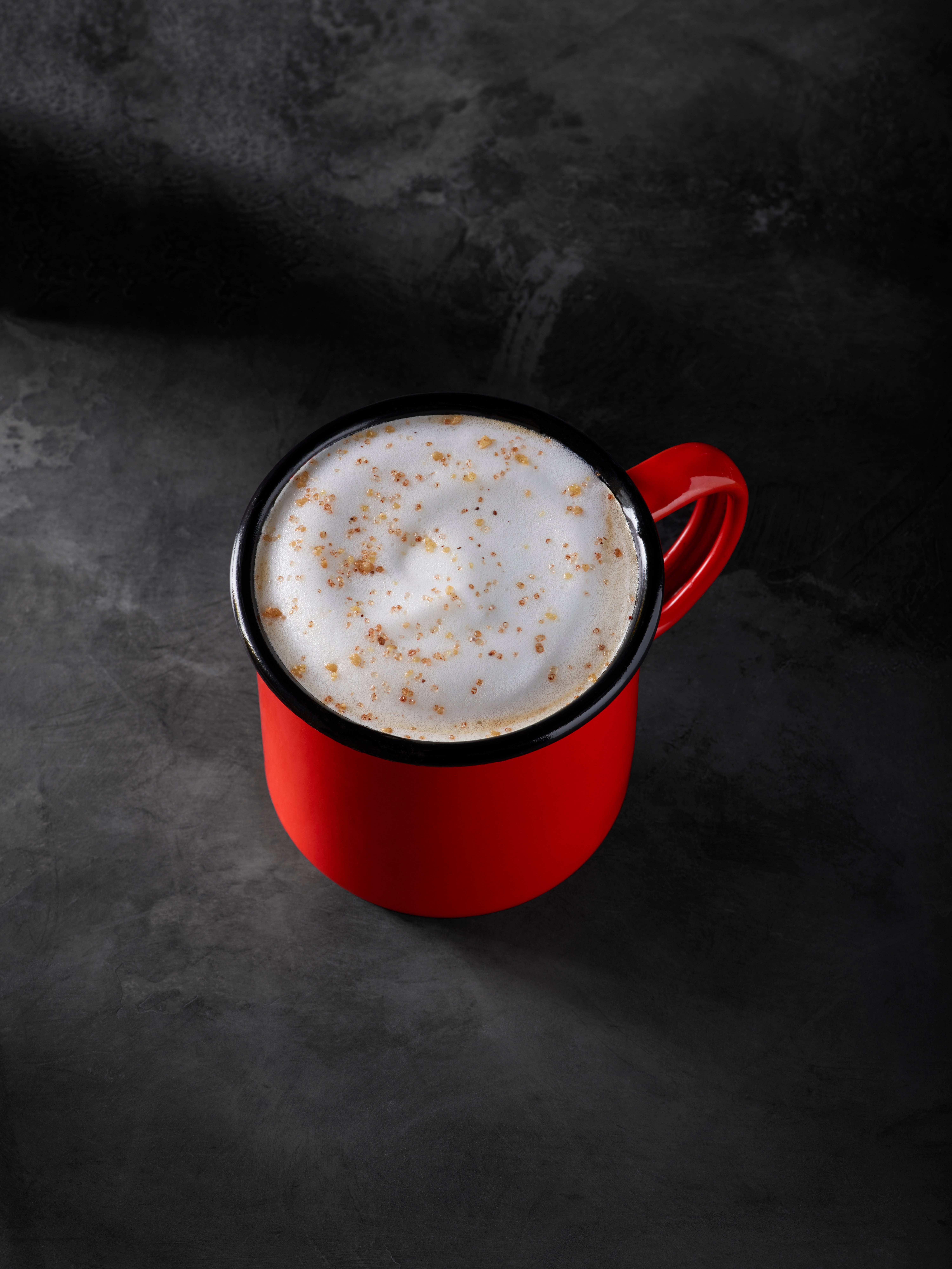 Chestnut Praline Chai Tea Latte in a red mug on a black background 