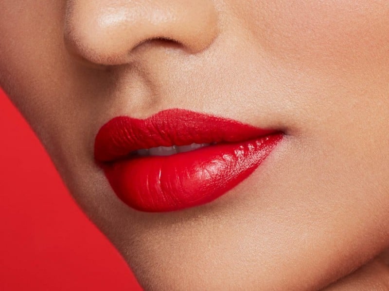 A model demonstrates how to prevent bleeding red lipstick for the holidays