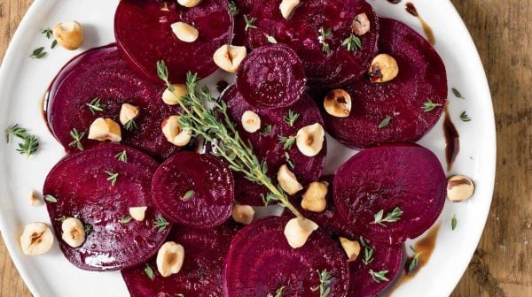 Oh She Glows Roasted beet salad topped with hazelnuts and herbs on white plate