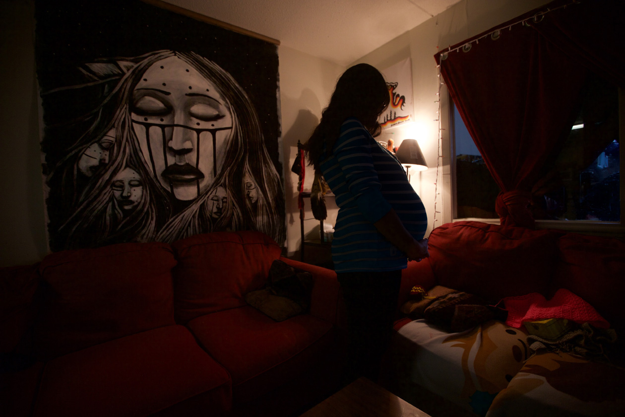 First Nations fighting foster care-Jen is pregnant and stands in profile hidden by shadow