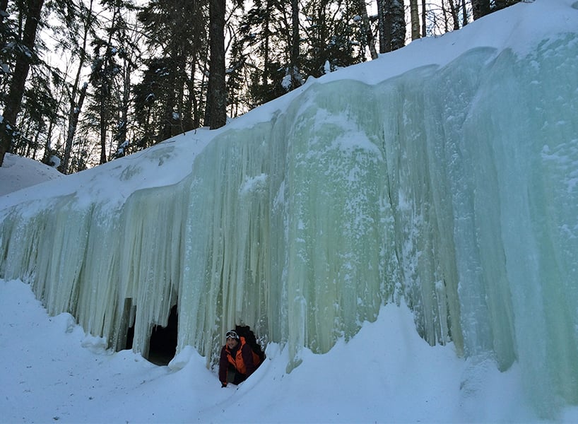 best outdoor winter activities-a man crawls out of the Midland-Ice-Caves-
