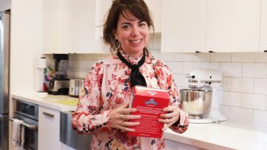 Amy Rosen holds box of matzah in her kitchen