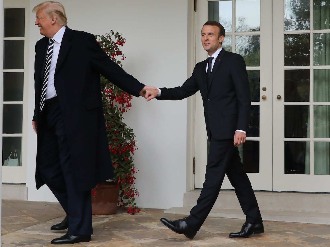 President Donald Trump and French President Emmanuel Macron holding hands