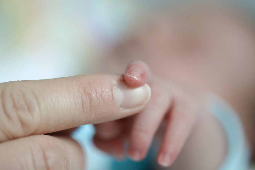 women who don't want children feature image of adult holding hand with newborn baby