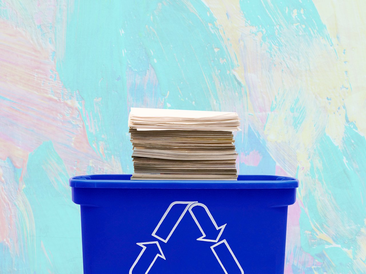 Recycling blue bin with stack of paper
