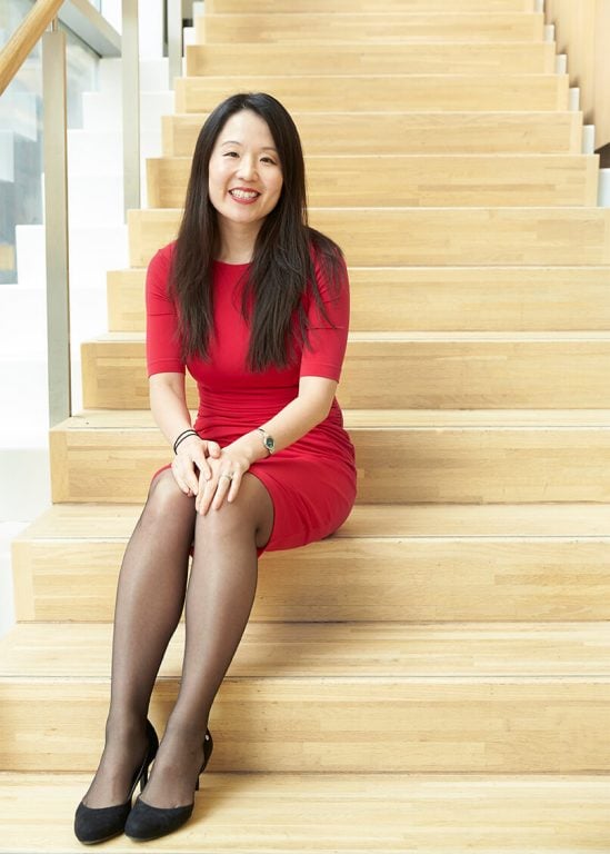 MS Researcher Jiwon Oh sits on some steps wearing a red dress.