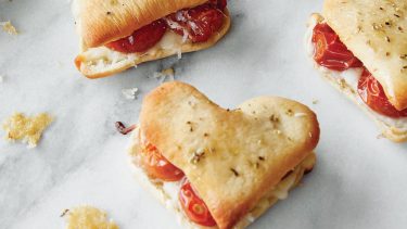 Heart-shaped pizza sandwiches on white marble