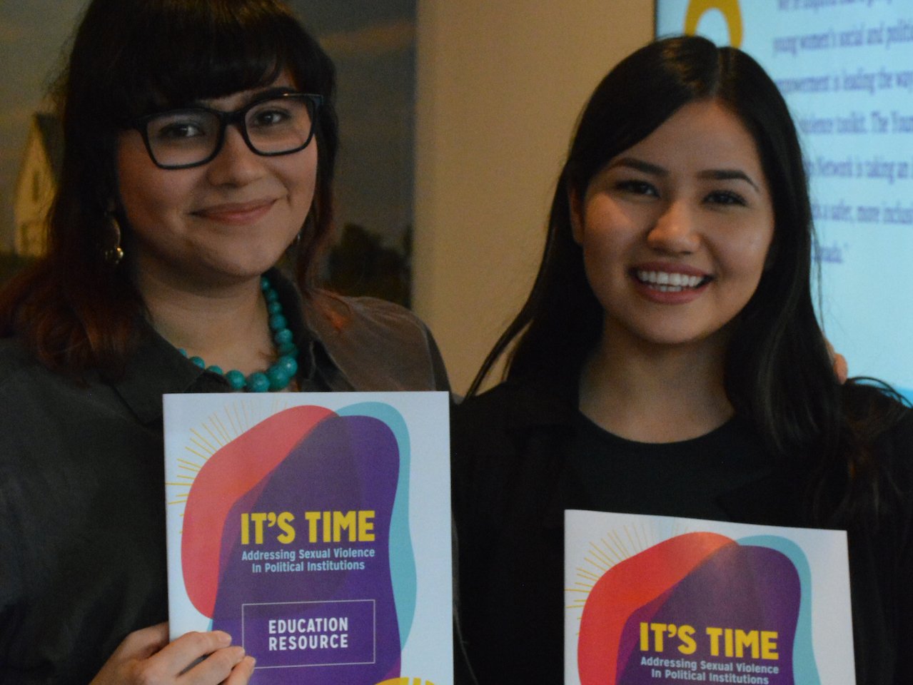 two women holding "It's Time" booklet