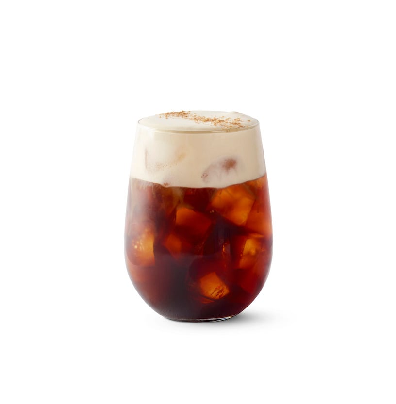 Glass filled with Starbucks cold brew topped with cold foam