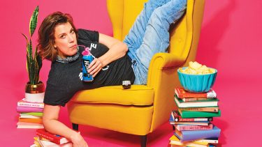 Carolyn Taylor lounges on a couch thinking about what to watch this summer while sipping on a beer