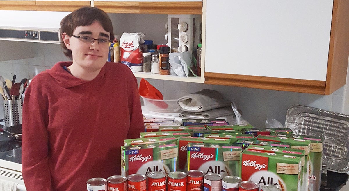 extreme couponer John Battaglia stands with a collection of cereal and canned goods