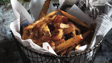 French fries in basket with newspaper lining.