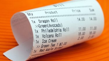 How much to spend dining out feature photo of a sushi receipt on an orange background