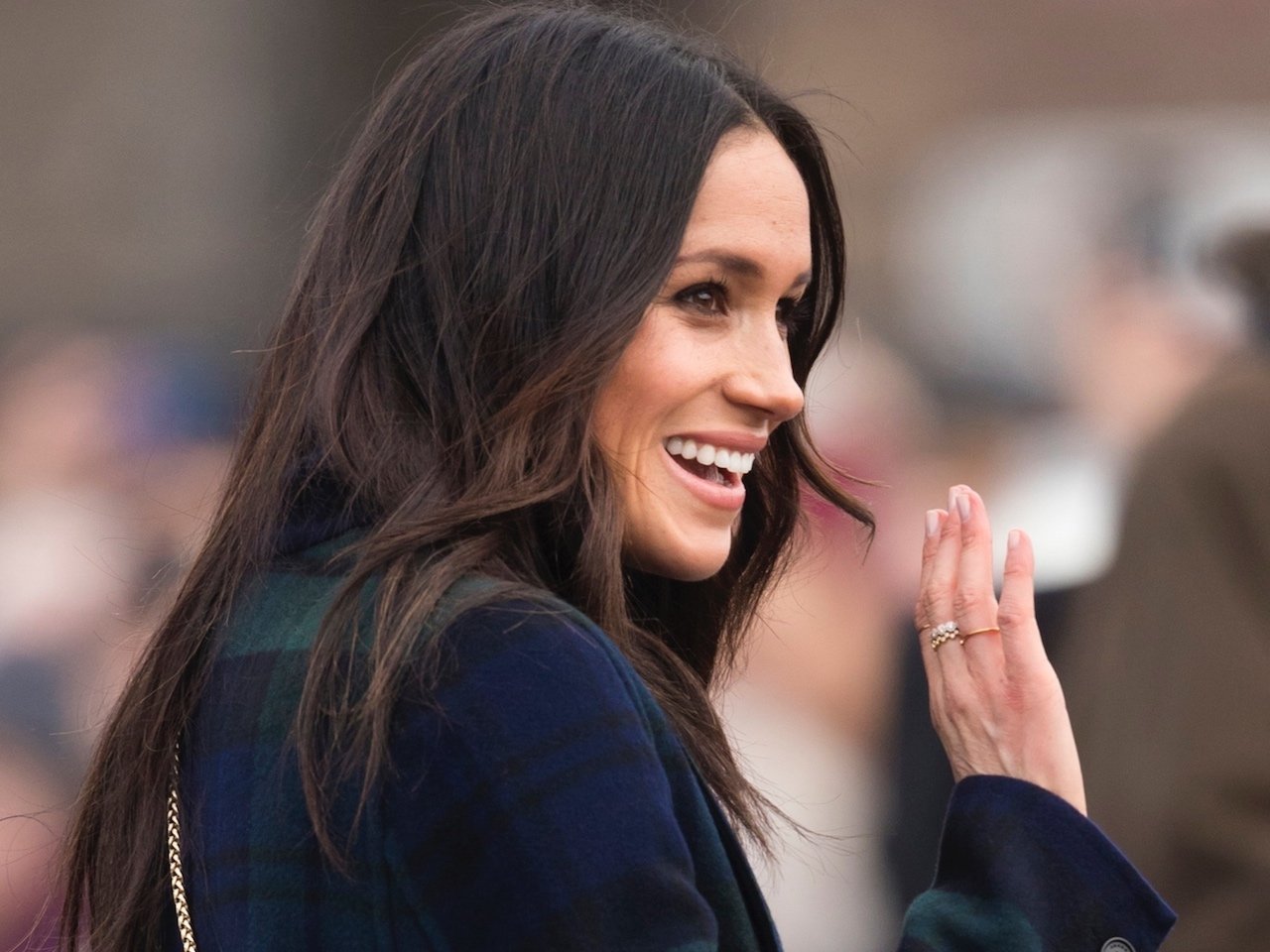 An image of Markle waving to a group of people during a walkabout in Edinburgh, Scotland.