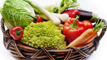 Refrigerator crisper drawer: vegetables in a wicker basket.