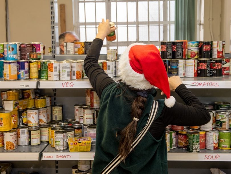 Food bank volunteer stacks food on shelves