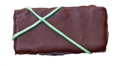 Peppermint chocolate snaps covered in dark chocolate and green icing on a white background