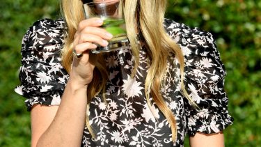 Gwyneth in black shirt drinking from glass, click to see Gwyneth Paltrow's Wedding gown
