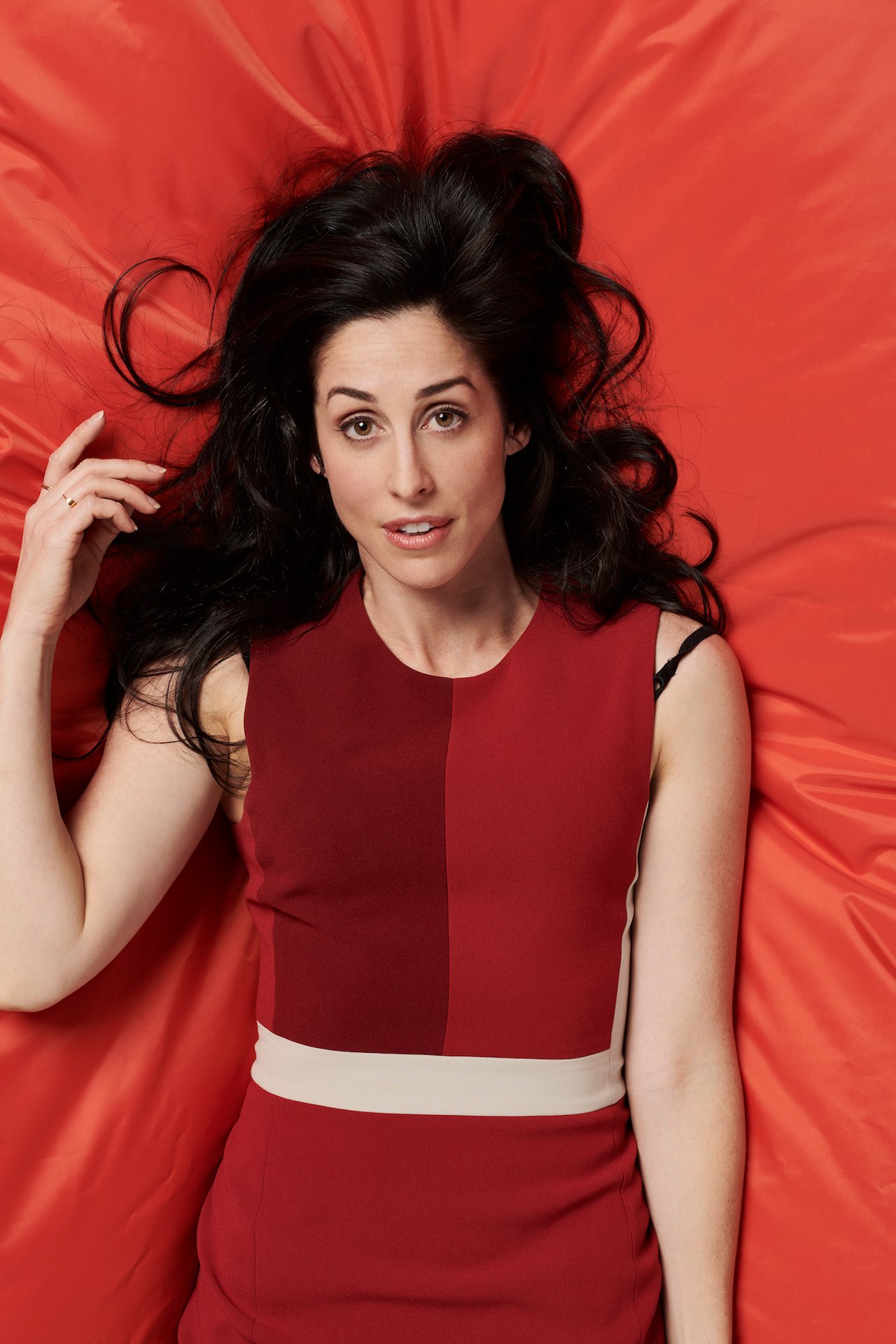Catherine Reitman writer of Workin Moms poses on a red background