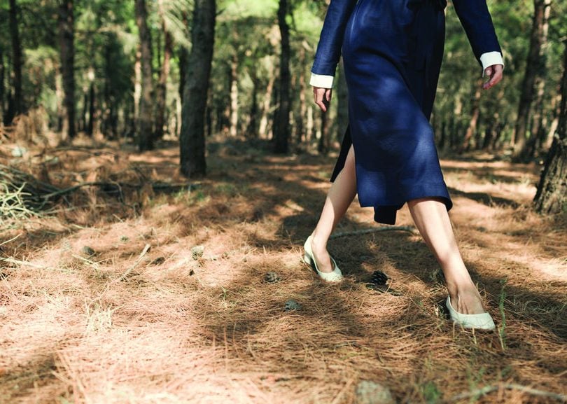 A woman walks through a forest to illustrate a piece on emotional affairs and cheating and infidelity