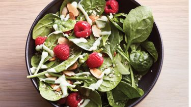 Spinach salad with avocado dressing and raspberries