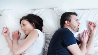 Sad and thoughtful couple after arguing lying in the bed